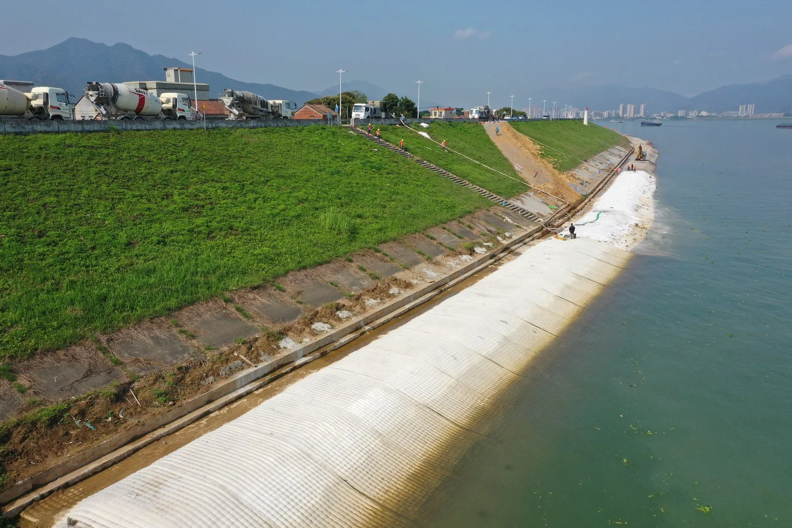 Coastal seawall installation with concrete trucks