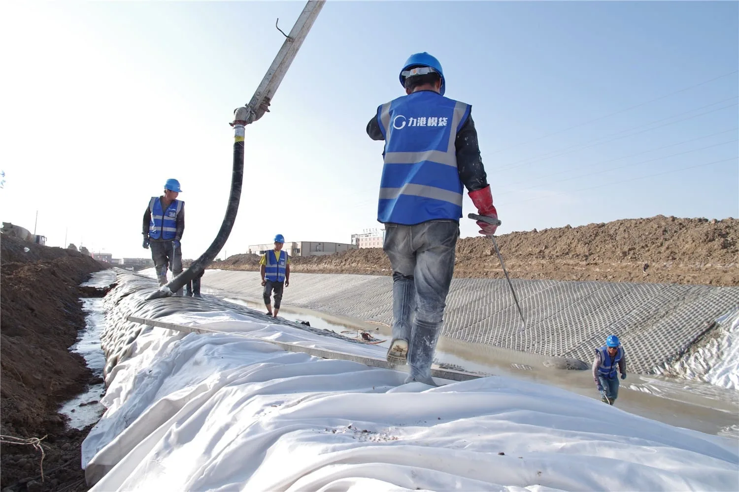 Workers injecting grout into slope mattress