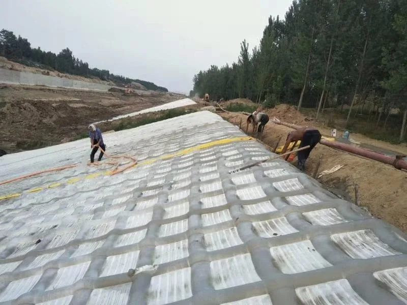 Workers laying grouted mattress on canal slope