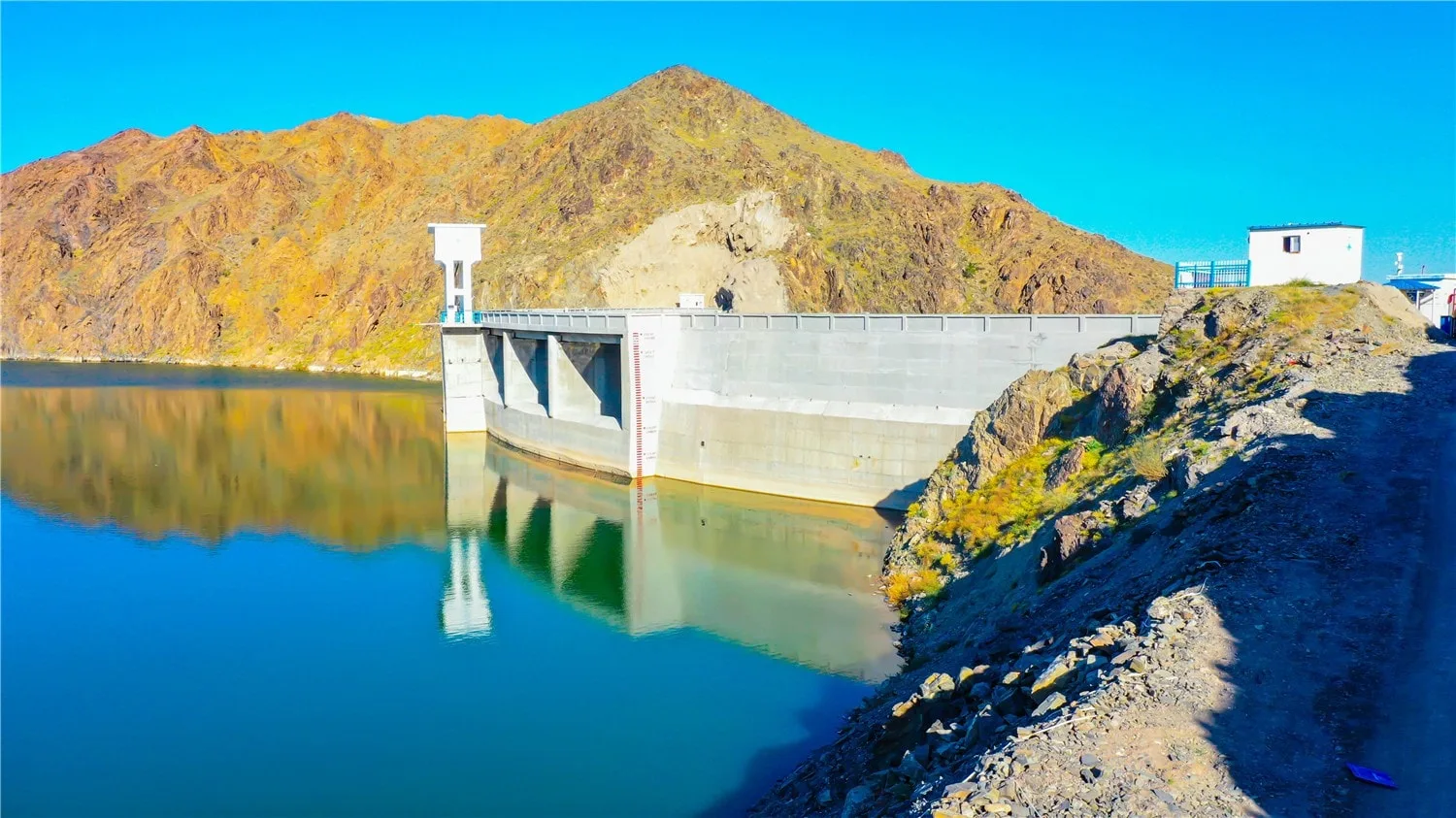 Dam gate structure with grouted mattress slope protection